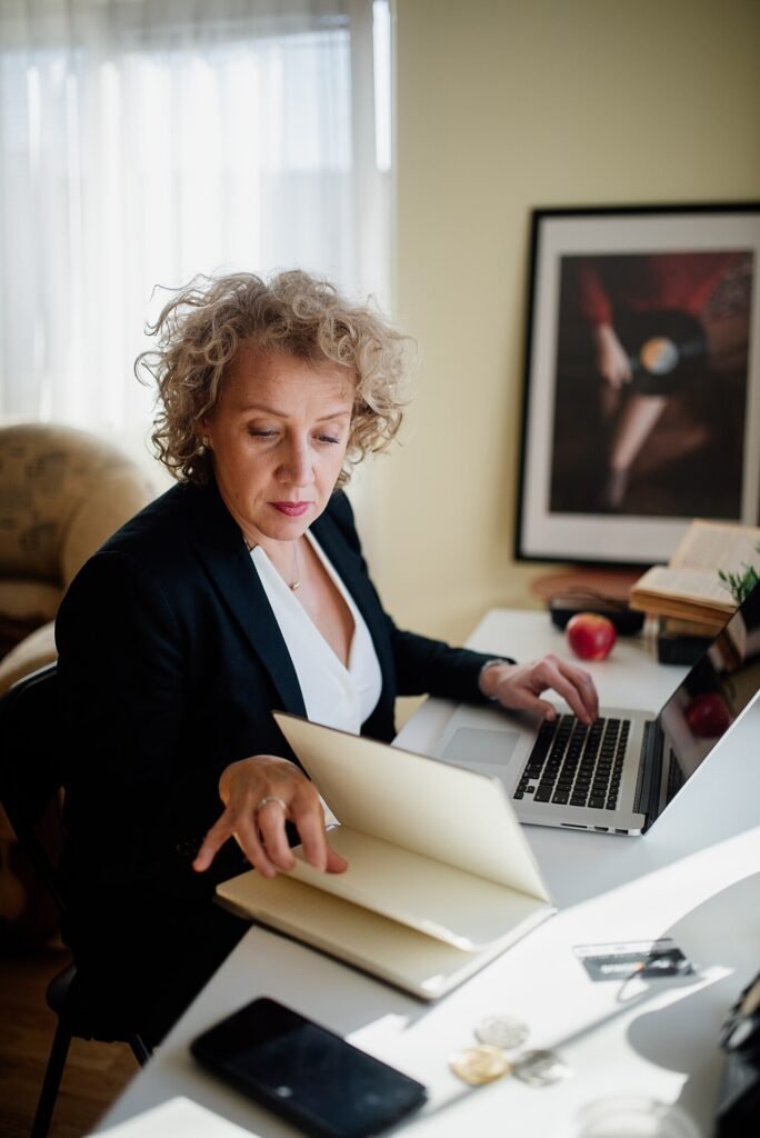 Payroll administrator reviewing salary documents on a laptop, the monthly SIF preparation that underpins WPS compliance for UAE free zone employers
